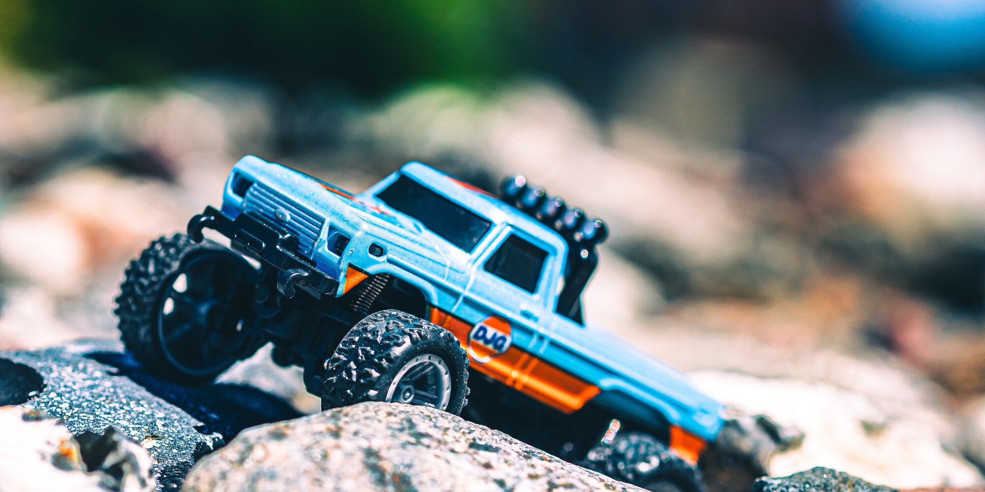 Mini RC car pickup Truck i blå på en sten stående skråt på sløret baggrund