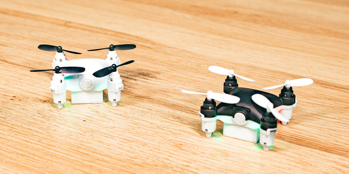 Hvid og sort Micro Drone på et træbord med lyset tændt