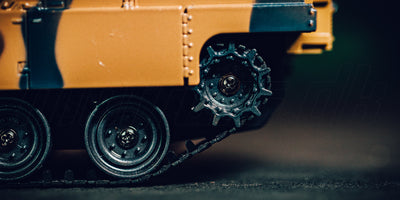 Grøn Battle Tank Metal Limited Edition fjernstyret kampvogn i camouflage kører gennem tørt græs i terrænet.