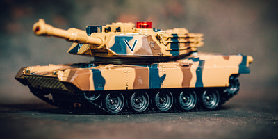 Battle Tank Metal Limited Edition fjernstyret kampvogn i camouflage kører gennem råt terræn med sand og sten.