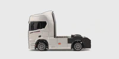 Sort Drift Truck fjernstyret lastbil med hvide detaljer og store dæk set fra siden på en hvid baggrund.