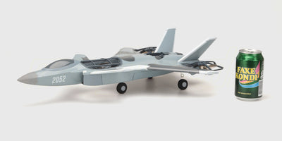 Grå Fighter Jet Brushless fjernstyret fly i luften med detaljeret cockpit og vinger på en klar blå himmel.
