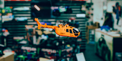 Grå C186 helikopter med fire propeller og detaljeret cockpit vist fra siden på en hvid baggrund.