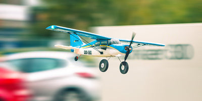 Hvidt QIDI-560 Brushless sportsfly med røde og sorte detaljer klar til flyvning i det fri.