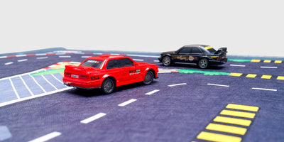 Gråt racerbane tæppe med vejbaner og parkeringspladser til leg med fjernstyrede biler.