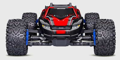 Blå Traxxas Rustler 4x4 BL-2S fjernstyret bil i fuld fart på en grusvej med støvskyer bag hjulene.