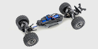 Grøn Traxxas Stampede 4x4 VXL monster truck i høj fart på en grusvej med støvskyer bag sig.