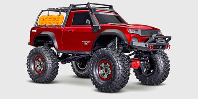 Traxxas TRX-4 Sport High Trail i rød med hævet undervogn og store dæk til offroad kørsel på stenet terræn.