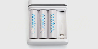 Hvid Eneloop batterioplader med fire genopladelige 1900mAh AA-batterier i original emballage.